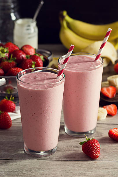 deux smoothies au yaourt à la fraise et à la banane des verres avec des produits - cocktail à la fraise photos et images de collection