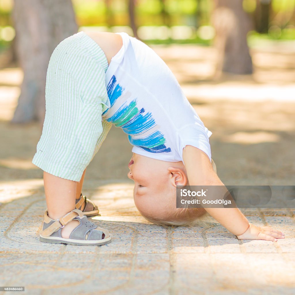 Baby yoga Baby doing yoga exercises. Downward Facing Dog pose. Adho Mukha Svanasana Baby - Human Age Stock Photo