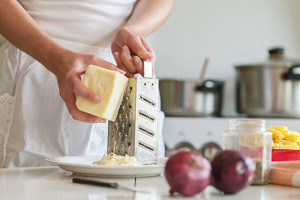 grating formaggio cheddar - grater foto e immagini stock