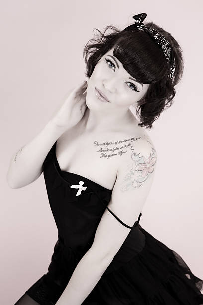 Pinup style woman tonned Toned image of Pinup style woman in black dress looking at camera black pin up girl tattoos stock pictures, royalty-free photos & images