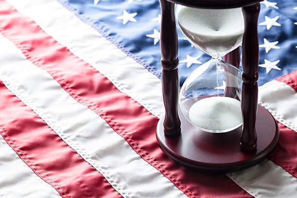 Time is running out American flag on flat surface laying flat with hourglass hour glass usa flag stock pictures, royalty-free photos & images