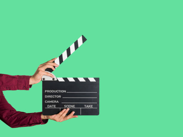 Man holding a movie clapperboard Man holding a movie clapperboard in a greenbox studio, with copy space to the right film slate stock pictures, royalty-free photos & images