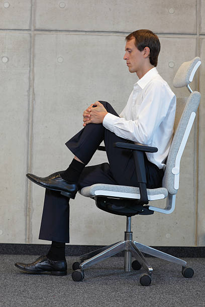 stretching in office on chair stock photo