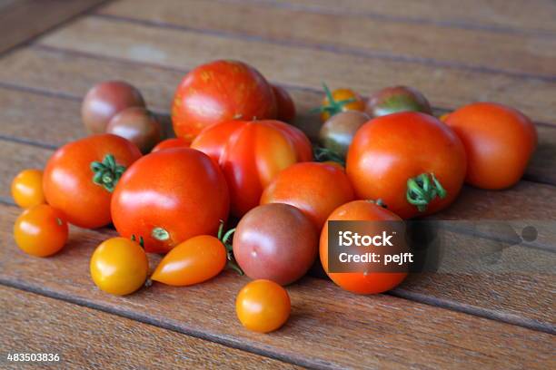 Fresh Newly Picked Organic Tomatoes On Teak Table Stock Photo - Download Image Now - 2015, Cherry Tomato, Environment