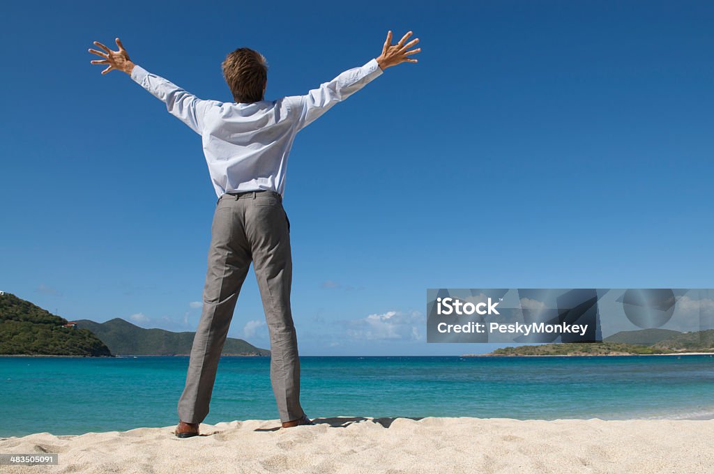 Empresário em pé com os braços abertos praia Tropical - Foto de stock de Alívio royalty-free