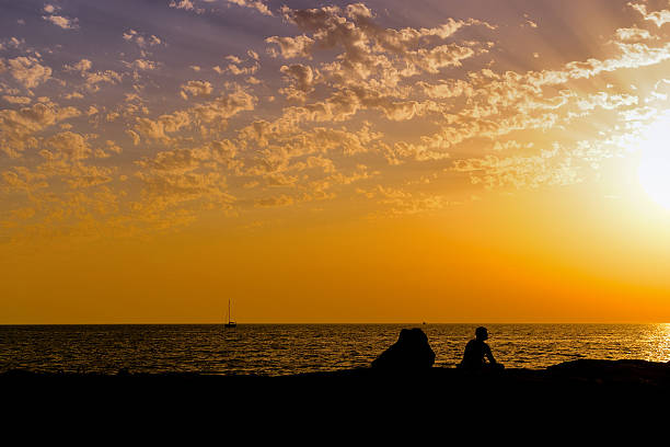 Man on reef at sunset stock photo