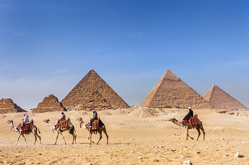 Bedouins raiding on camels, pyramids on the background, Giza, Egypt.http://bem.2be.pl/IS/egypt_380.jpg
