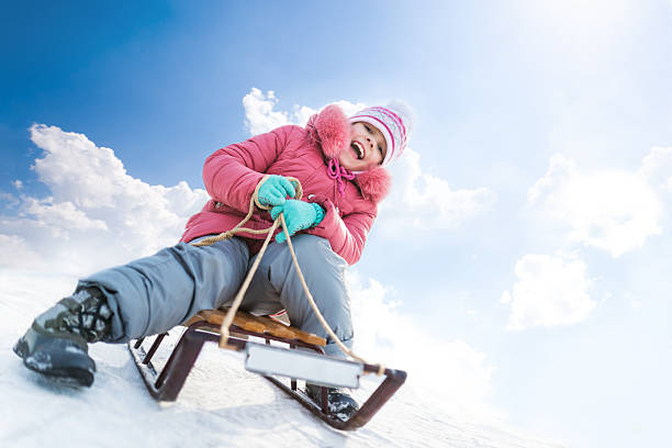 Kid sliding with sledding in the snow. 