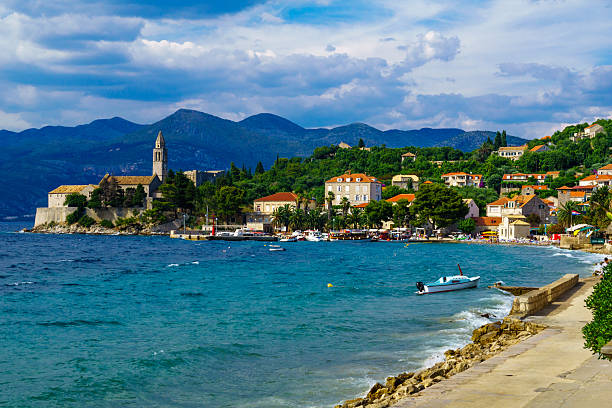 Lopud Beach and Port Lopud, Croatia - June 27, 2015: Scene of the fishing port and the beach, with the Franciscan Monastery, boats, locals and tourists, in the village Lopud, Lopud Island, one of the Elaphiti Islands, Croatia dubrovnik lopud stock pictures, royalty-free photos & images