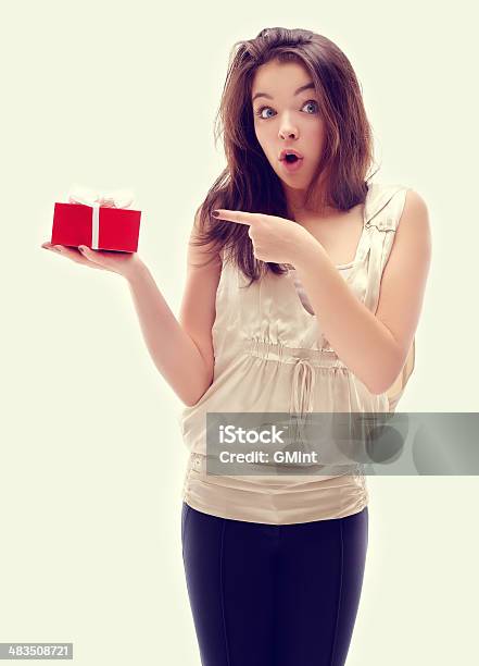 Surprised Girl Holding Gift Looking At Camera Stock Photo - Download Image Now - Adolescence, Adult, Asking