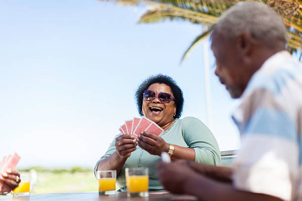 istock African senior women having a good laugh while playing cards 483510343