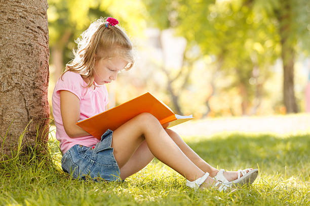 istock Cute little girl is reading a book 483517558