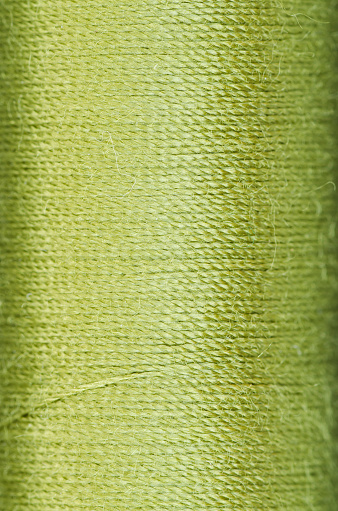 bobbin of green thread background texture macro