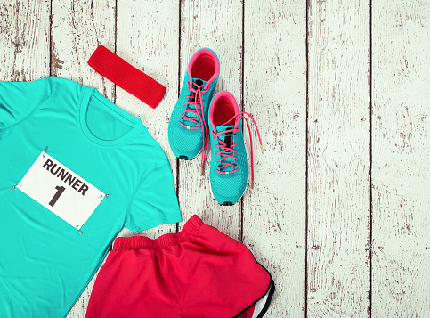 Running gear laid out ready for a race day, rustic wooden background with copy space