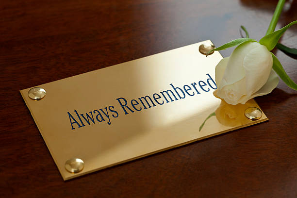 Always Remembered Always Remembered. A brass plaque bearing the enamelled inscription Always Remembered, fixed to a mahogany coffin, with a single white rose bloom. coffin photos stock pictures, royalty-free photos & images