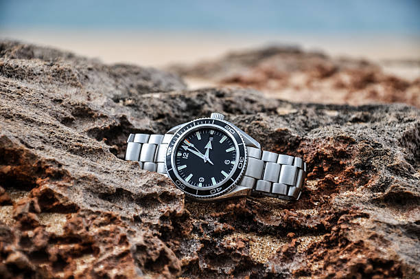 Wrist watch on a rock stock photo