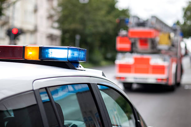 Police car and fire engine truck at the place of action - flashing bluelight, siren - selective focus
