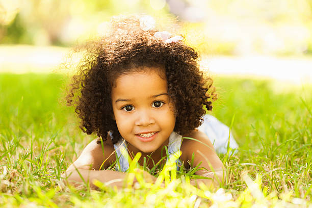 istock Smiling Little Girl Lying On Grass 483528143