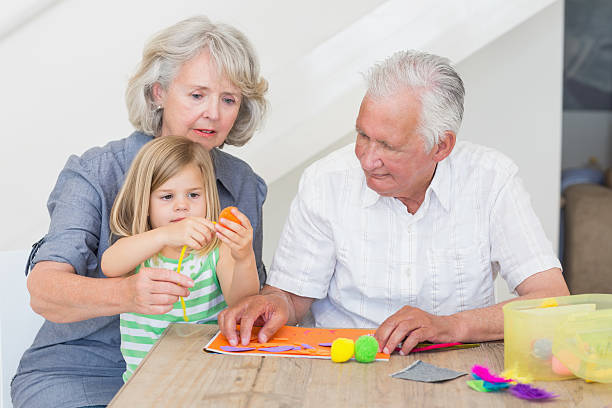 istock Grandparents with granddaughter doing craft work 483528485