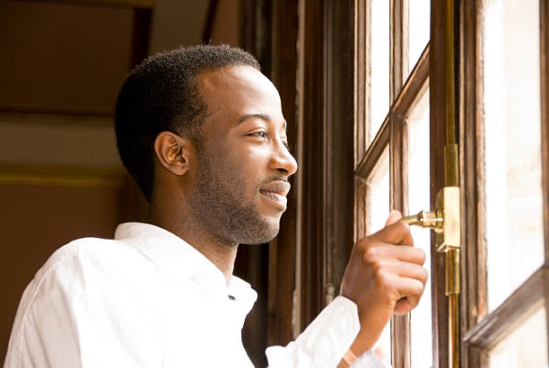 istock Young African American Male looking out window 483530999
