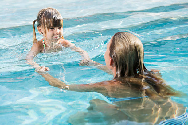 istock Mother and daughter in swimming pool 483531651