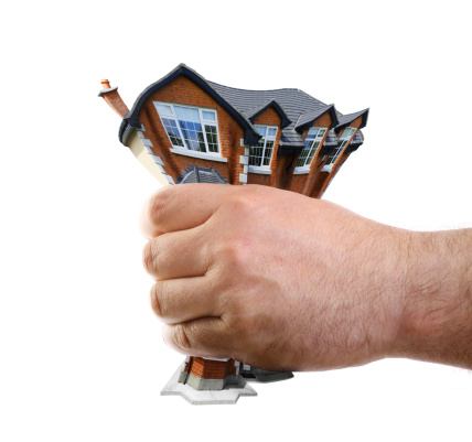 hand squeezing a house