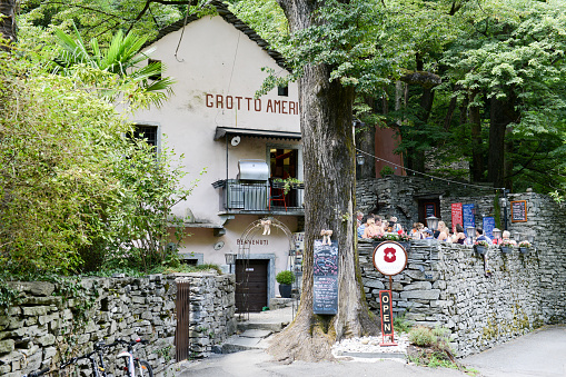 Ponte Brolla, Switzerland - 30 July 2015: People eating on a Grotto, a typical restaurant on the italian part of Switzerland at Ponte Brolla on Maggia valley