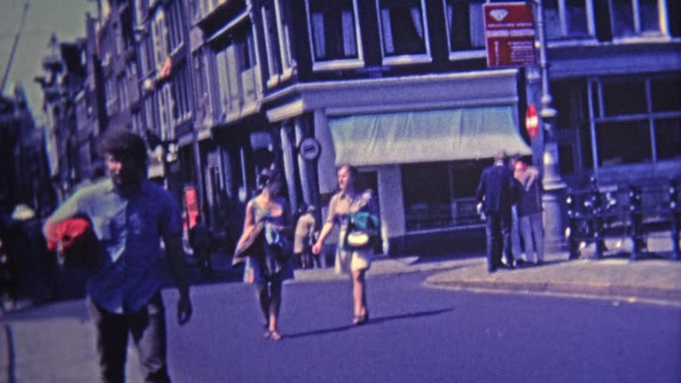 1969: Bohemian district of town people walking and biking narrow streets.