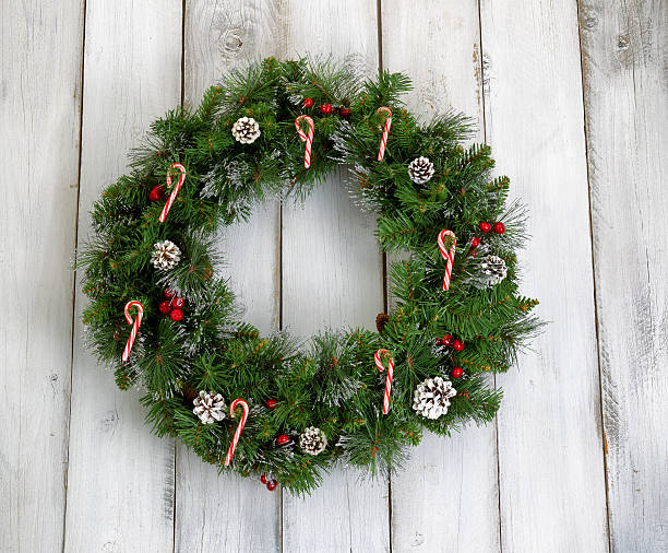 istock Christmas wreath with decorations on rustic white wooden boards 483540022