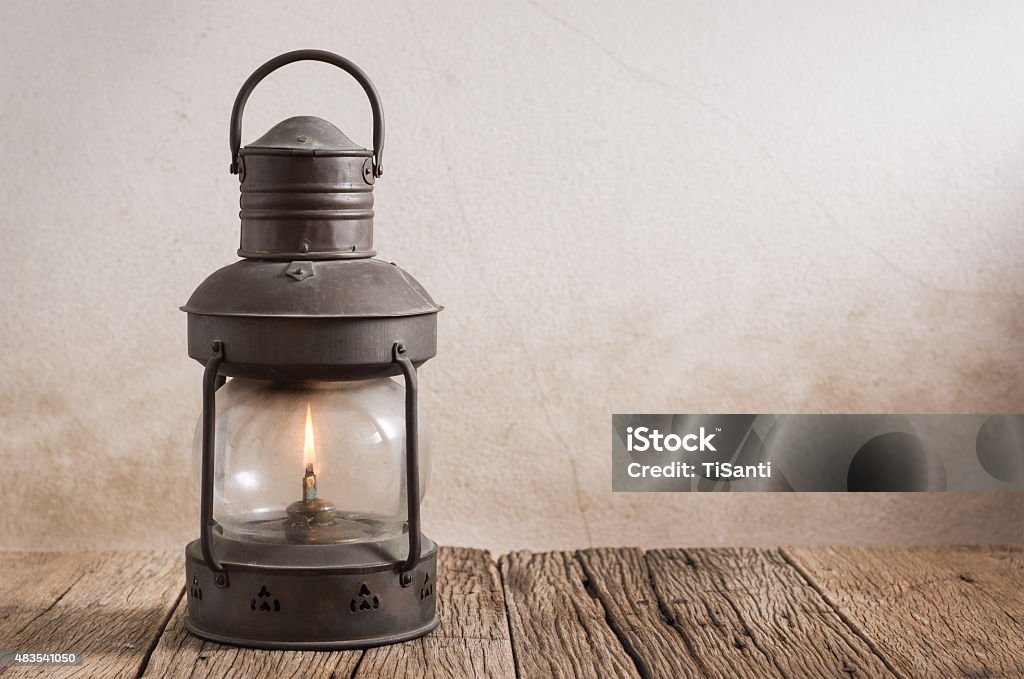 old lantern on wood old kerosene lantern on old wood with grunge wall Lantern Stock Photo