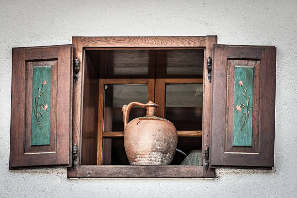 istock Old jug standing in wide open wooden window. 483543210