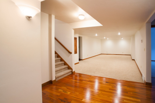 Amplia terminado sótano con alfombras y pisos de madera photo