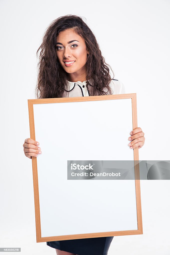 Pretty businesswoman holding blank board Smiling pretty businesswoman holding blank board isolated on a white background 2015 Stock Photo