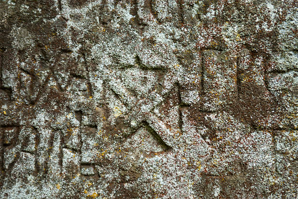 istock Moss-grown surface of the old stone cross 483550416