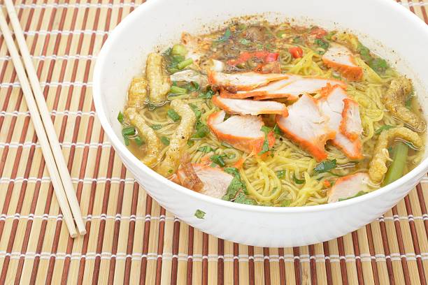istock Egg noodle soup with red roast pork, top view 483551364