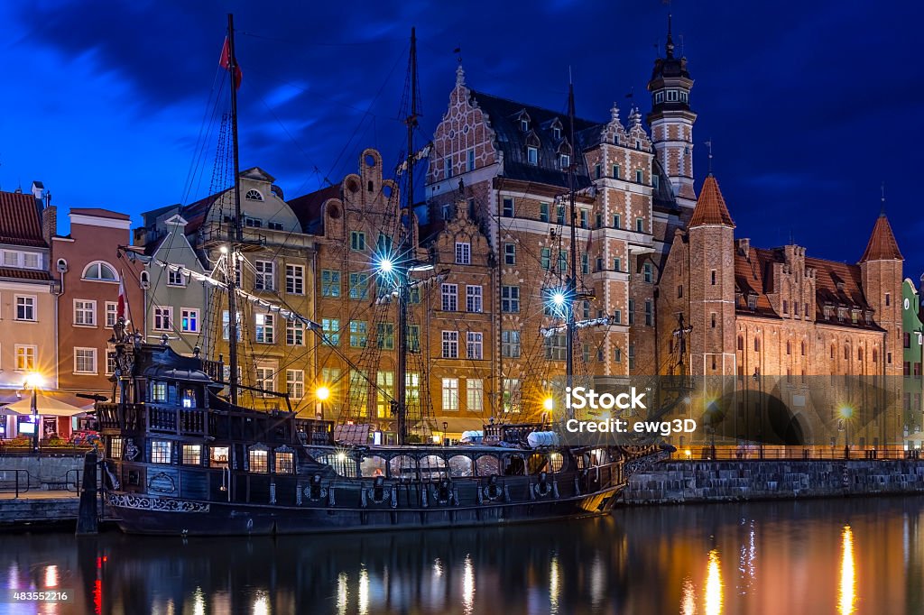 Old Town in Gdansk by night, Poland The classic view of Gdansk with the hanseatic-style buildings and historical tourist boat moored on the River Motlawa, Poland  17th Century Style Stock Photo