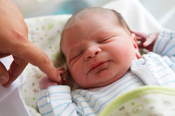istock newborn baby holding her father's finger 483552936