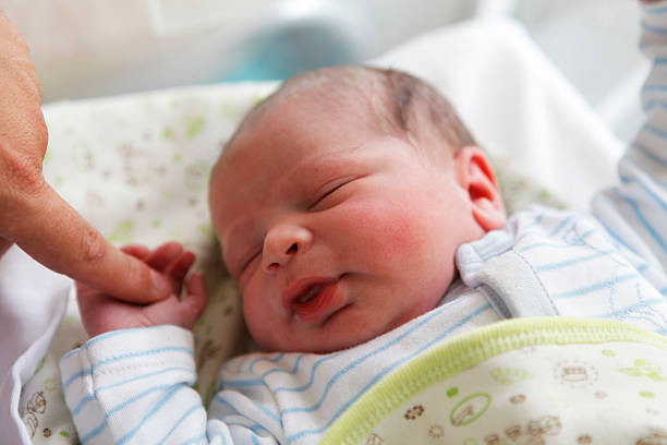 istock newborn baby holding her father's finger 483552940