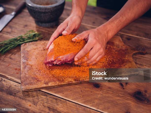 Person Rubbing Dry Seasoning Into A Piece Of Raw Pork Stock Photo - Download Image Now