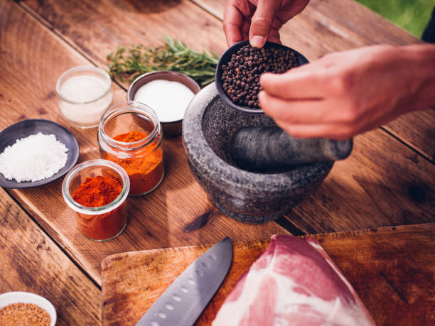 istock Black peppercorns being put into a mortar and pestle 483555130