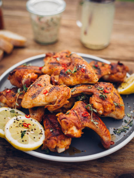 istock Tempting spicy chicken wings on a plate with lemon slices 483555136
