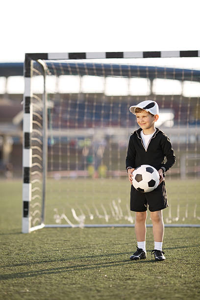 istock boy plays football on stadium 483555260