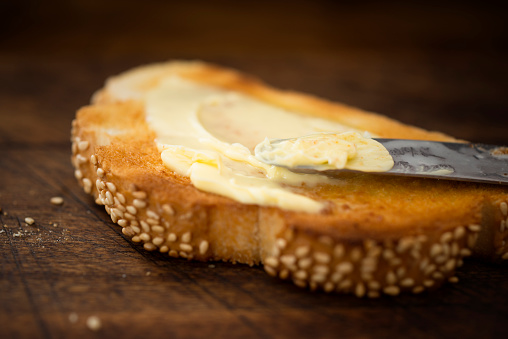 Close up of a slice of white toast covered in melting butter.