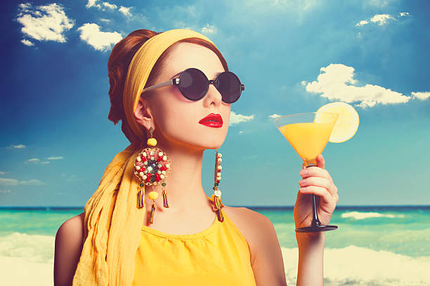 mulher bonita com cabelo ruivo cocktail na praia. - image created 1960s 1960s style beach women imagens e fotografias de stock