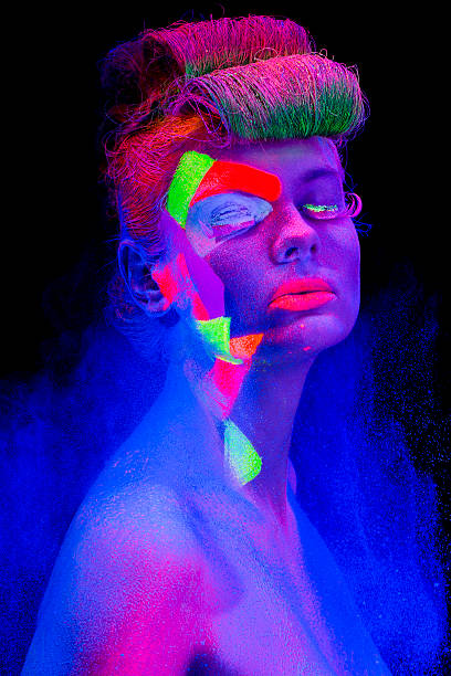 istock Women Portrait with Glowing makeup in black light 483558431