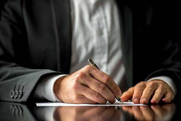 Last Will and Testament document Conceptual image of a man signing a last will and testament document. probate photos stock pictures, royalty-free photos & images