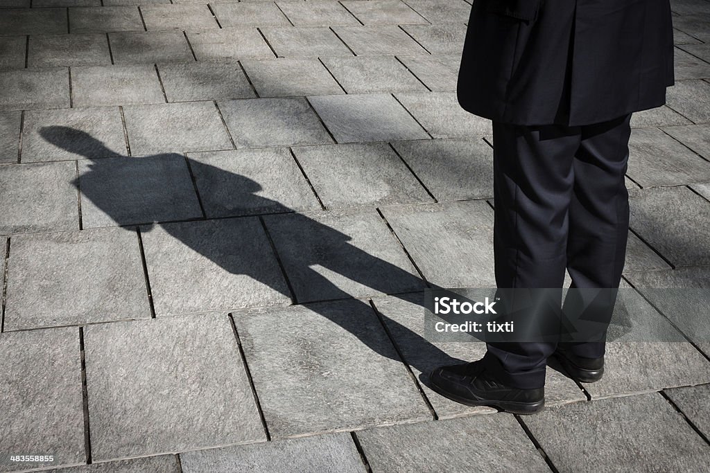 Shadow of a businessman standing Floor with shadow of a businessman standing Adult Stock Photo