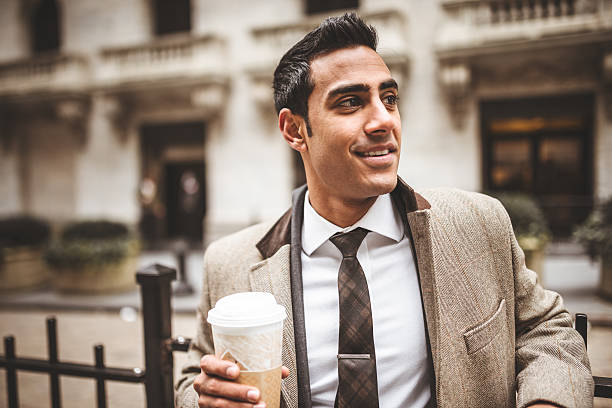 istock Businessman with coffee mug on wall street 483562041