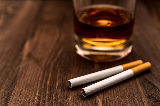 istock Glass of whiskey and two cigarettes 483562868