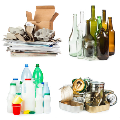 A selection of garbage for recycling. Segregated metal, plastic, paper and glass on white background